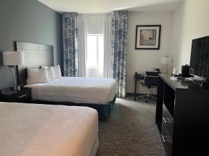 a hotel room with two beds and a desk at The Grove Inn and Suites in Eagle Grove