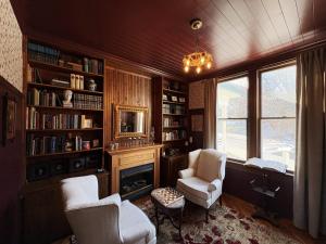 a room with two chairs and a desk and a fireplace at Avery House Bed & Breakfast in Galena