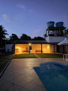 a house with a swimming pool in front of it at Bahia Executivo Pousada in Zeca