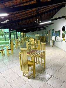 a dining room with wooden tables and chairs at Bahia Executivo Pousada in Zeca