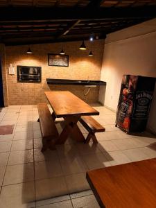 a wooden table and benches in a room at Bahia Executivo Pousada in Zeca +13 photos