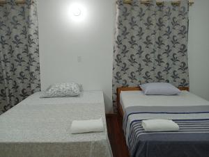 two twin beds in a room with a wall at Hospedaje La Casa del Sauce in Obligado