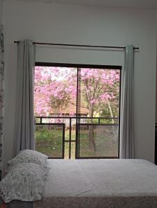 a bedroom with a bed and a window with pink flowers at Hospedaje La Casa del Sauce in Obligado