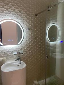 a bathroom with a sink and a glass shower at Home in Kutaisi +8 photos