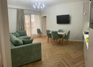 a living room with a couch and a table with chairs at Home in Kutaisi