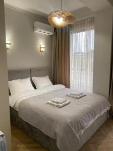 a bedroom with a large bed with two towels on it at Home in Kutaisi