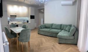 a living room with a green couch and a table at Home in Kutaisi