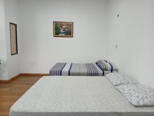 a bed sitting in a room with a couch at Hospedaje La Casa del Sauce in Obligado