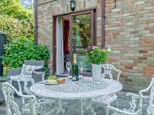 a table with flowers and wine glasses on a patio at 1 Bed in Lymington oc-92403 in Ripley