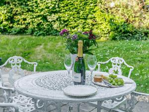 a table with a bottle of wine and wine glasses at 1 Bed in Lymington oc-92403 in Ripley