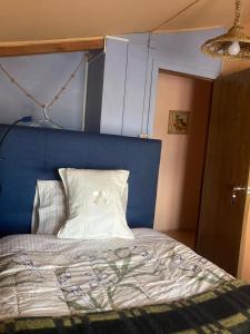 a bedroom with a bed with a blue head board at Hostal Art Gallery Chiloè in Castro