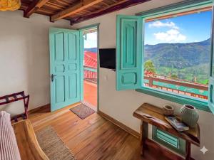 a room with a table and a large window at Canela Mountain Villa Hotel in Salento