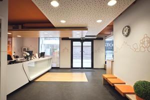 an office lobby with a reception counter and benches at easyHotel Brussels City Centre in Brussels +27 photos