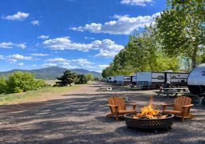 a campground with two chairs and a fire pit at Grand Canyon RV Glamping in Williams