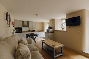 a living room with a couch and a kitchen at Dunsa Cottage Bakewell Peak District in Bakewell