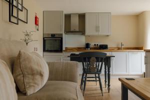 a living room with a couch and a table and a kitchen at Dunsa Cottage Bakewell Peak District in Bakewell