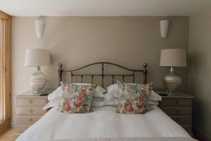 a bedroom with a bed with pillows and two lamps at Dunsa Cottage Bakewell Peak District in Bakewell +6 photos