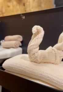 a white towel animal sitting on top of a bed at L'Industriel in Drummondville