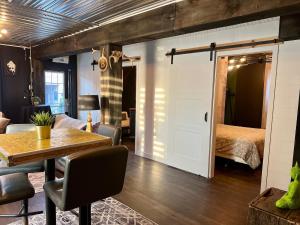a living room with a table and a bedroom at L'Industriel in Drummondville
