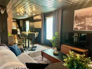 a living room with a couch and a television at L'Industriel in Drummondville +33 photos