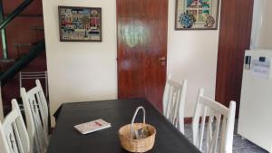 a dining room with a black table and white chairs at Brisas Pura in Tandil