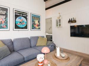 a living room with a blue couch and a tv at Idyllic Nature Retreat - By Traum Ferienwohnungen in Ulfborg