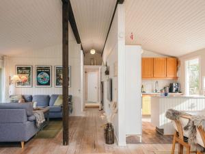 a living room with a blue couch and a kitchen at Idyllic Nature Retreat - By Traum Ferienwohnungen in Ulfborg