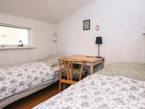 a room with two twin beds and a wooden table at Idyllic Nature Retreat - By Traum Ferienwohnungen in Ulfborg