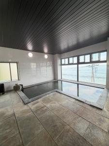a large room with a swimming pool in a building at HOTEL&RESORT Izu no Ne in Higashiizu