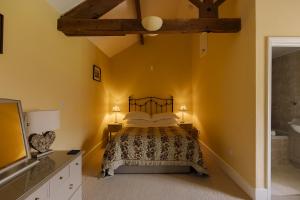 a bedroom with a bed with yellow walls at Edensor Cottage Bakewell Peak District in Bakewell
