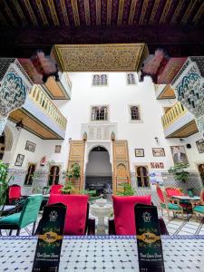 a patio with colorful chairs and tables in a building at Riad Green House in Fez