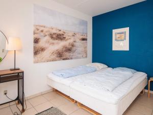 a bed in a room with a blue wall at 7 person holiday home in Ringkøbing in Ringkøbing