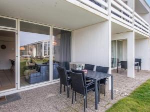 a patio with a table and chairs on a house at 7 person holiday home in Ringkøbing in Ringkøbing +28 photos