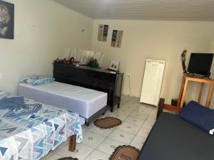 a bedroom with two beds and a dresser and a mirror at Suíte completa com cozinha no centro de Aquidauana in Aquidauana
