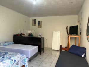 a bedroom with a bed and a tv in it at Suíte completa com cozinha no centro de Aquidauana in Aquidauana