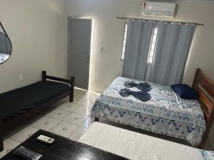 a small bedroom with a bed and a table at Suíte completa com cozinha no centro de Aquidauana in Aquidauana +2 photos