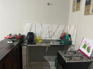 a small kitchen with a stove and a sink at Suíte completa com cozinha no centro de Aquidauana in Aquidauana