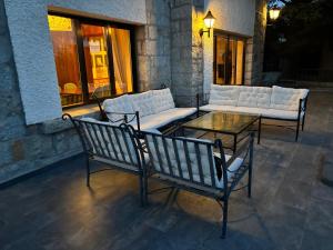 a patio with couches and a table and chairs at Los Cedros, gran chalet con piscina en Navacerrada in Navacerrada