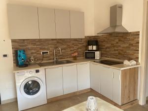 a kitchen with white cabinets and a washing machine at Near Sea in Monopoli
