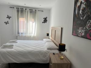 a bedroom with a large white bed and a window at Mil Mariposas, Escapada rural Burgos in Barriosuso