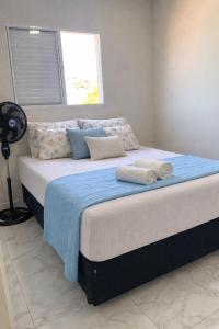 a bed with towels on it in a bedroom at Apartamento in Espirito Santo Do Pinhal