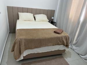 a bedroom with a large bed with a brown blanket at Vila dos Ventos in São Pedro da Aldeia +23 photos