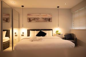a bedroom with a large white bed and a chair at Westfield luxurious Apartment in Birmingham