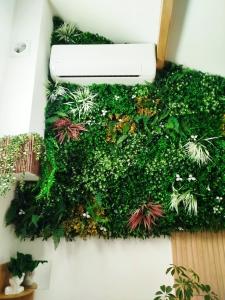 a green wall with plants and a light on it at Le Perchoir de Linas, filet suspendu, appartement cosy in Linas +24 photos