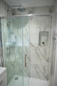 a shower with a glass door in a bathroom at Westfield luxurious Apartment in Birmingham +25 photos