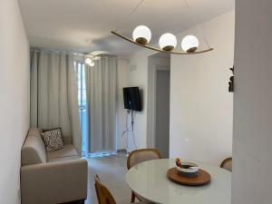 a living room with a table and a couch at Vila dos Ventos in São Pedro da Aldeia