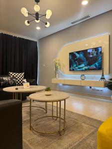 a living room with two tables and a tv at Luxury suite- 1bhk- Near Centaurus in Islamabad