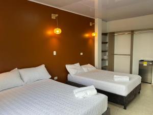 a bedroom with two beds and a refrigerator at Casa Lemora in Vergara