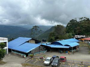 a building with blue roofs and cars parked in a parking lot at Casa Lemora in Vergara
