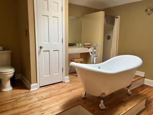 a white bath tub in a bathroom with a toilet at Iron Horse Station in Hot Springs
